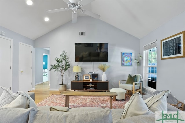 living room with ceiling fan, light hardwood / wood-style floors, and vaulted ceiling