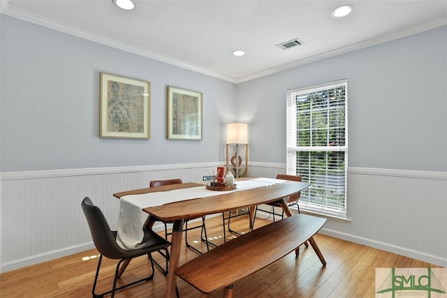 dining area featuring a healthy amount of sunlight, light hardwood / wood-style floors, and crown molding