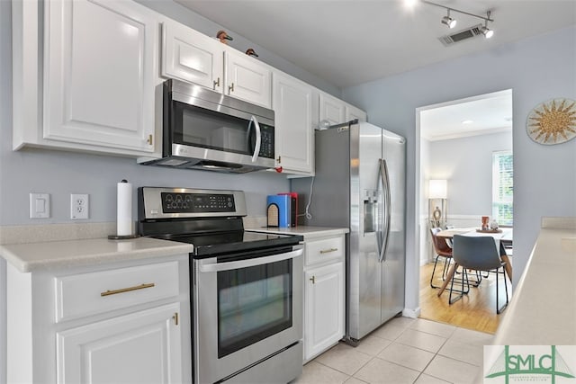 kitchen featuring white cabinets, appliances with stainless steel finishes, and light tile patterned flooring