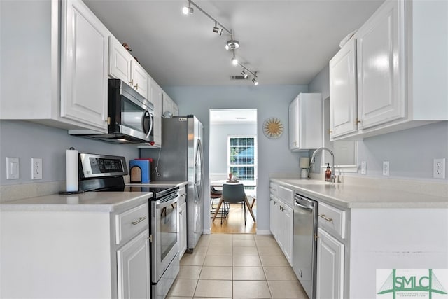 kitchen with white cabinets, light tile patterned flooring, sink, and appliances with stainless steel finishes