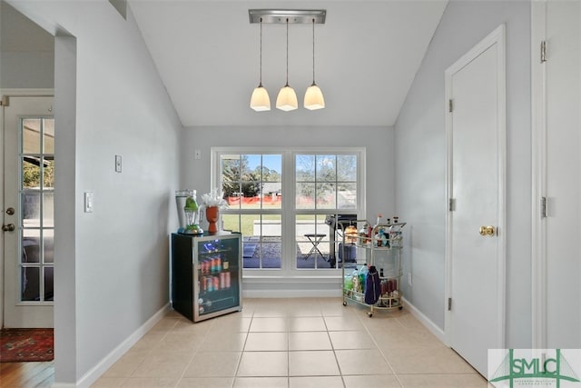 interior space with light tile patterned floors and vaulted ceiling