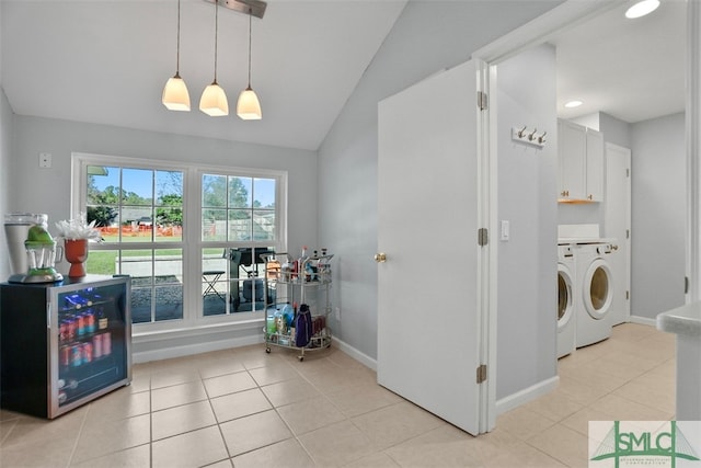 washroom featuring light tile patterned flooring, cabinets, separate washer and dryer, and wine cooler