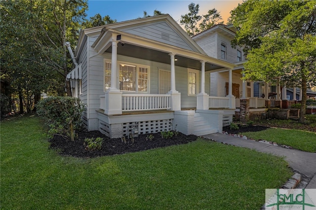 view of front of home featuring covered porch and a lawn