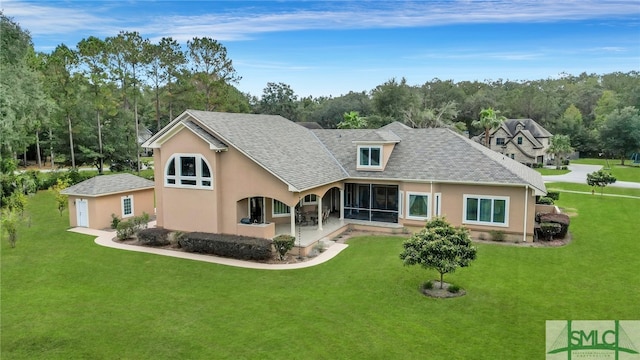 rear view of house featuring a sunroom, a patio, and a lawn