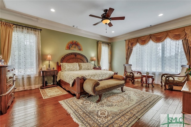 bedroom featuring hardwood / wood-style floors, ceiling fan, and crown molding