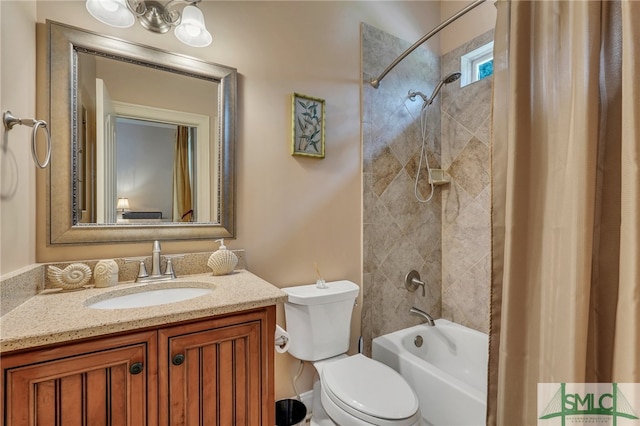 full bathroom with vanity, tiled shower / bath combo, and toilet