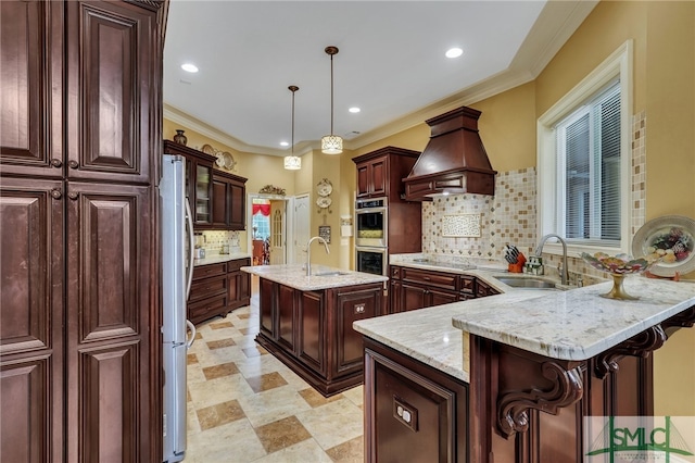 kitchen with premium range hood, sink, a kitchen island with sink, and backsplash