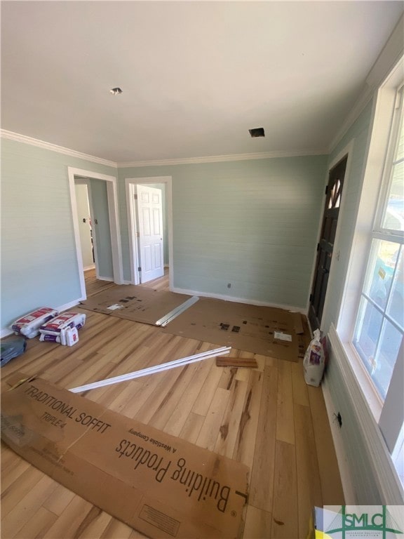 interior space featuring crown molding, hardwood / wood-style floors, and a healthy amount of sunlight