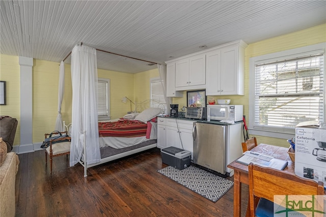 18 E 34th St, Savannah, GA 31401 - kitchen featuring freestanding refrigerator, white microwave, dark wood-style flooring, white cabinets, and dark countertops