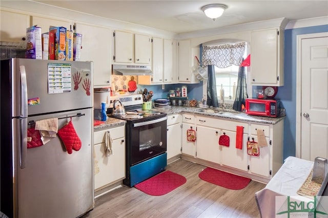 kitchen featuring sink, light hardwood / wood-style flooring, appliances with stainless steel finishes, white cabinetry, and light stone countertops