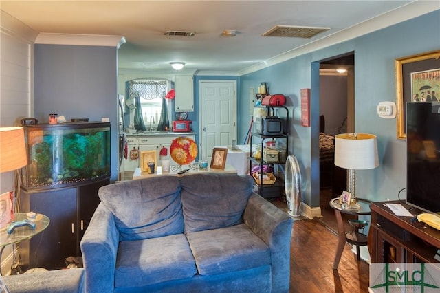 living room featuring ornamental molding, sink, and hardwood / wood-style floors