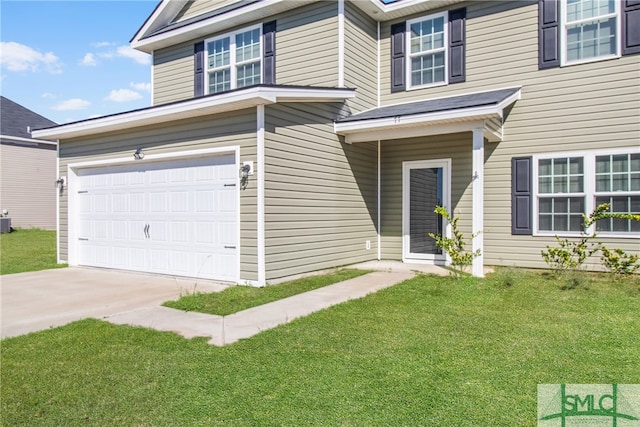 view of property featuring a front lawn and a garage