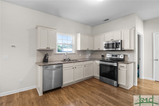 kitchen featuring white cabinetry, sink, and appliances with stainless steel finishes