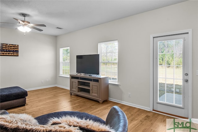 living room with ceiling fan, a healthy amount of sunlight, and light wood-type flooring