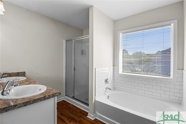 bathroom with plus walk in shower, vanity, hardwood / wood-style flooring, and a healthy amount of sunlight