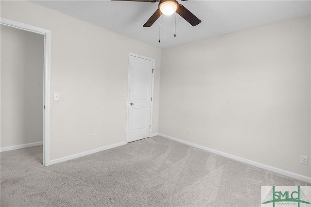 interior space with ceiling fan and light colored carpet