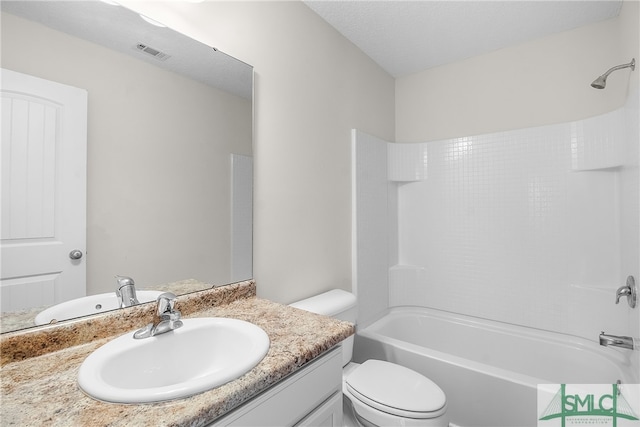 full bathroom with vanity, toilet, a textured ceiling, and bathing tub / shower combination