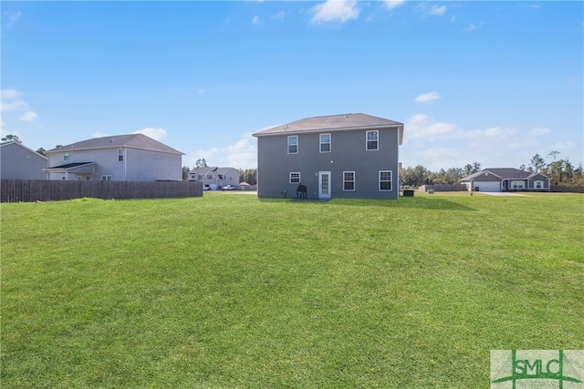 rear view of house featuring a yard