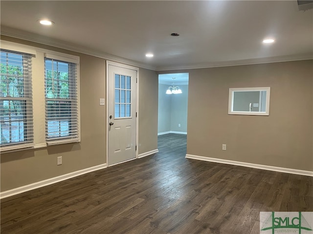 entryway featuring an inviting chandelier, crown molding, and dark wood-type flooring