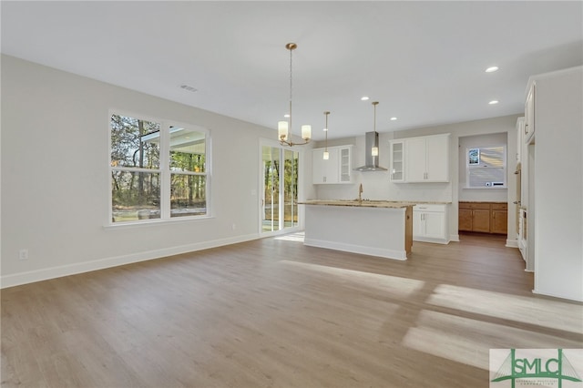 unfurnished living room featuring light hardwood / wood-style floors, sink, and a chandelier