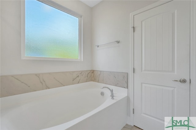 bathroom with a washtub and a healthy amount of sunlight