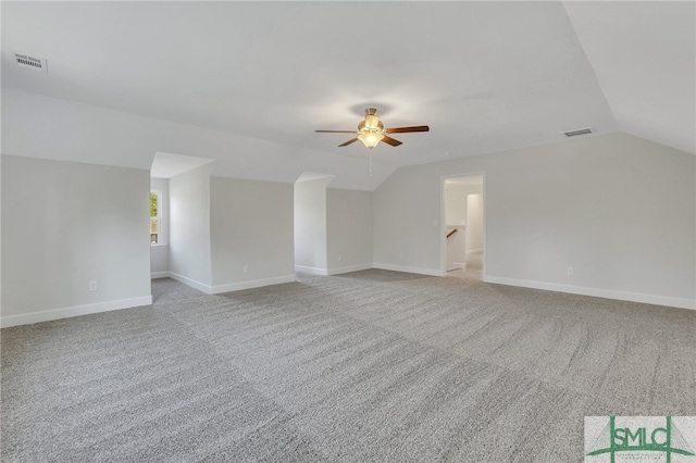 interior space featuring ceiling fan, light colored carpet, and vaulted ceiling