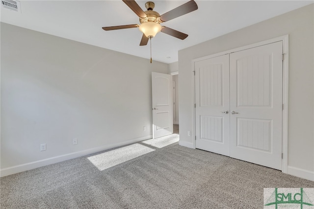 unfurnished bedroom with ceiling fan, light carpet, and a closet