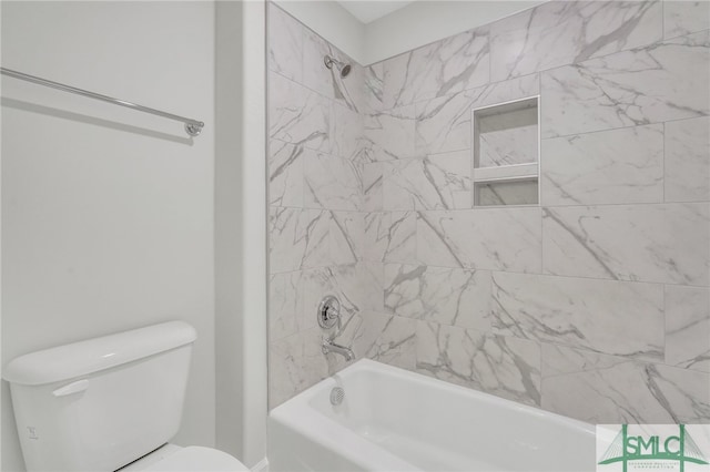 bathroom with tiled shower / bath combo and toilet