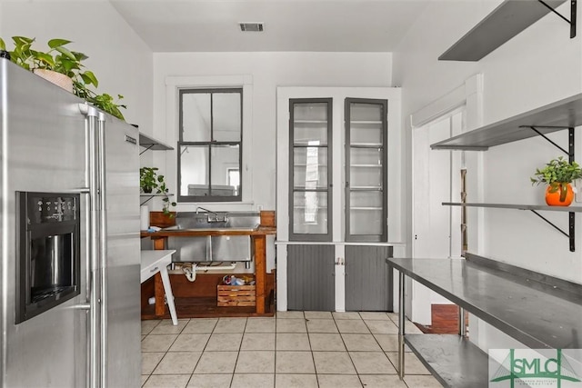 kitchen with light tile patterned floors, sink, and high quality fridge