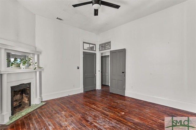 unfurnished living room featuring ceiling fan and dark hardwood / wood-style flooring