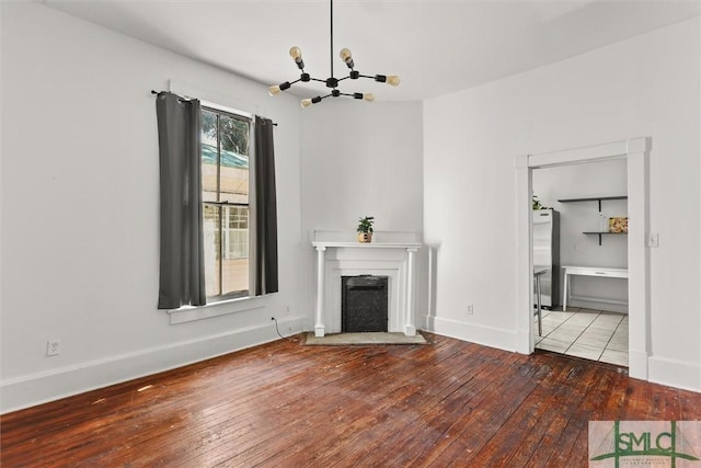 unfurnished living room with a chandelier and wood-type flooring