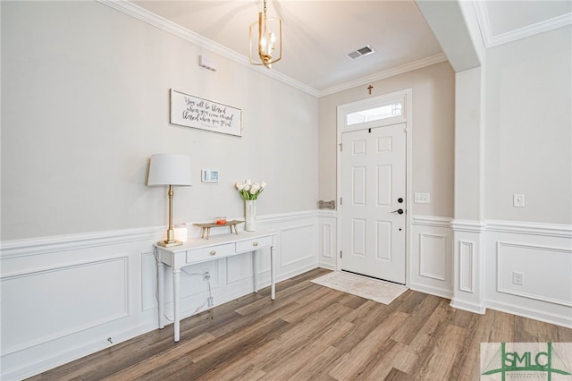 foyer entrance with wood-type flooring and ornamental molding