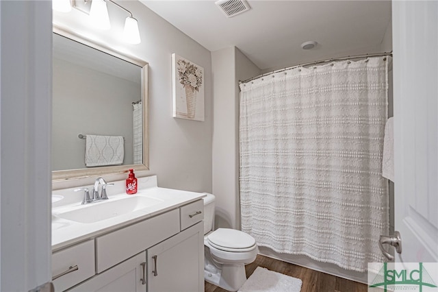 bathroom with curtained shower, vanity, wood-type flooring, and toilet