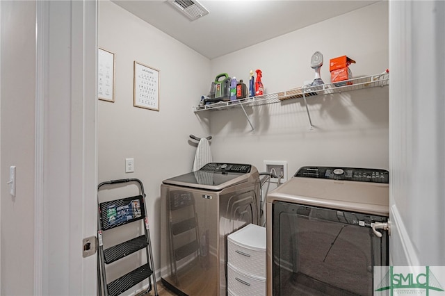 clothes washing area featuring washing machine and dryer and heating unit