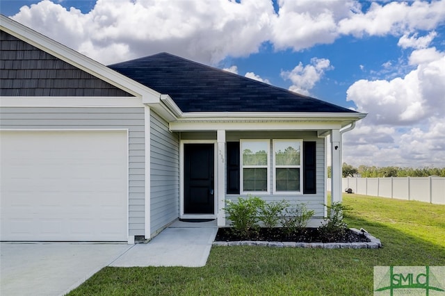 entrance to property featuring a garage and a lawn