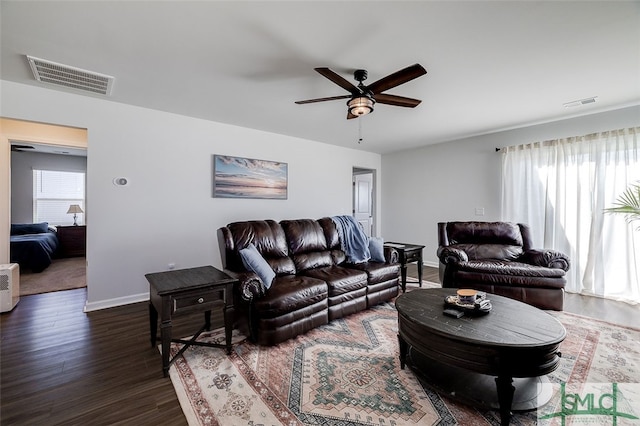 living room with ceiling fan and dark hardwood / wood-style flooring