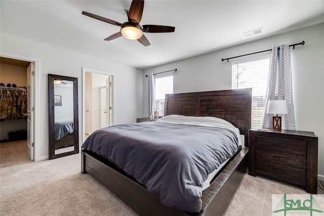 bedroom featuring ceiling fan, a walk in closet, multiple windows, and a closet