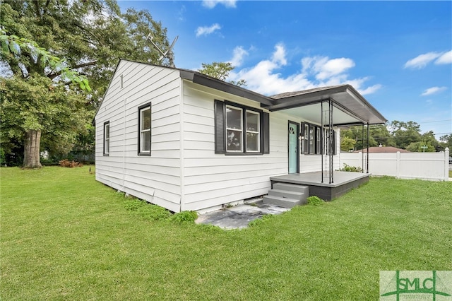 back of property featuring covered porch and a yard