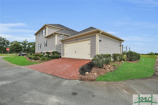 view of side of property featuring a garage and a yard