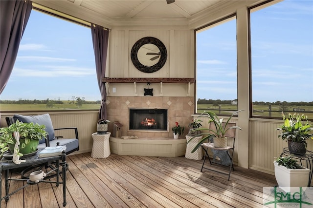 sunroom / solarium featuring a fireplace and a rural view