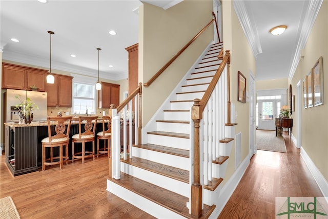 staircase with crown molding and hardwood / wood-style floors