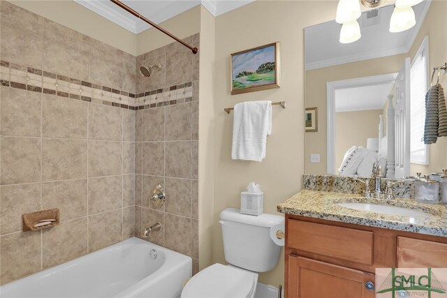 full bathroom featuring crown molding, vanity, tiled shower / bath combo, and toilet