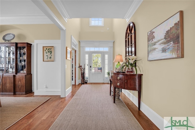 entrance foyer featuring crown molding and light wood-type flooring