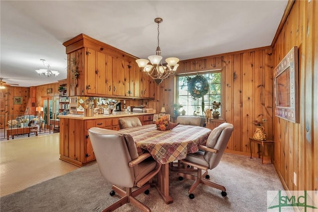 1462 Marlborough Way, Savannah, GA 31406 - dining space featuring a chandelier, wooden walls, light colored carpet, and ceiling fan