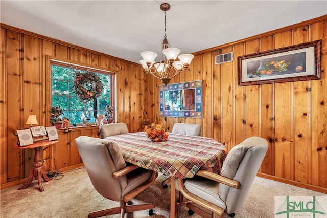 carpeted dining room with a notable chandelier, ornamental molding, and wooden walls