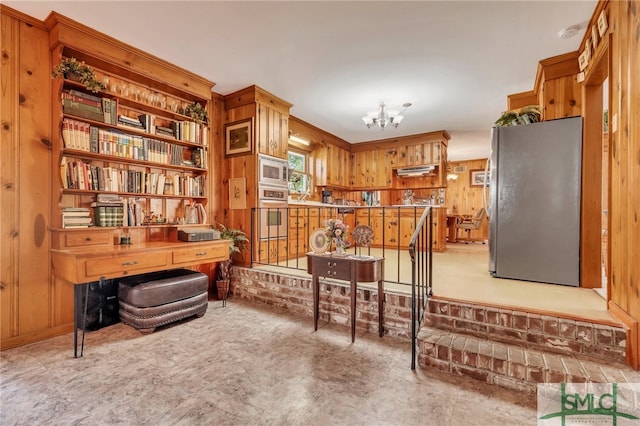 sitting room featuring wood walls and an inviting chandelier