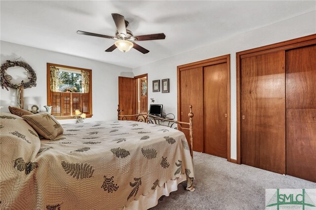 bedroom with carpet flooring, ceiling fan, and multiple closets