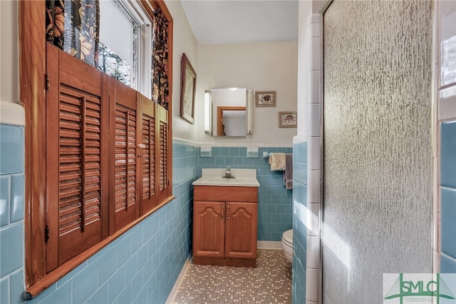 bathroom featuring tile patterned flooring, vanity, tile walls, and a wealth of natural light