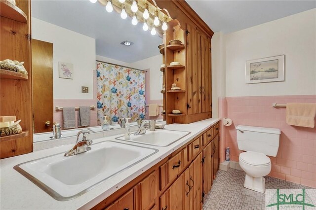 1462 Marlborough Way, Savannah, GA 31406 - bathroom with toilet, tile patterned flooring, tile walls, wainscoting, and double vanity