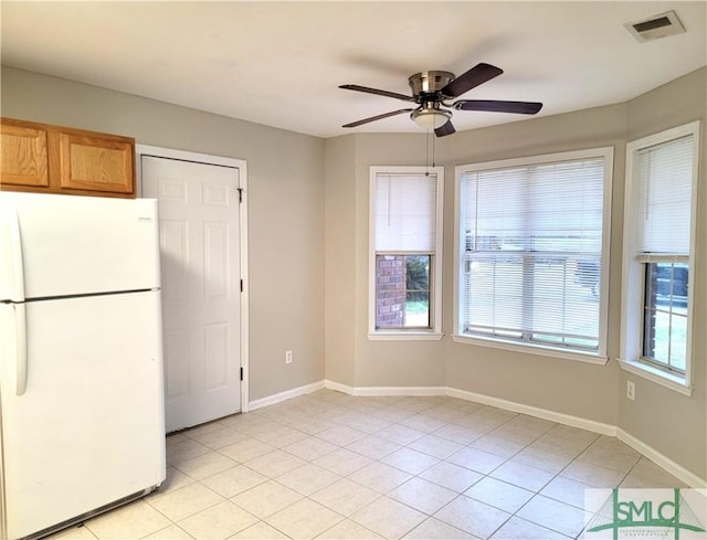 interior space with visible vents, baseboards, ceiling fan, and freestanding refrigerator